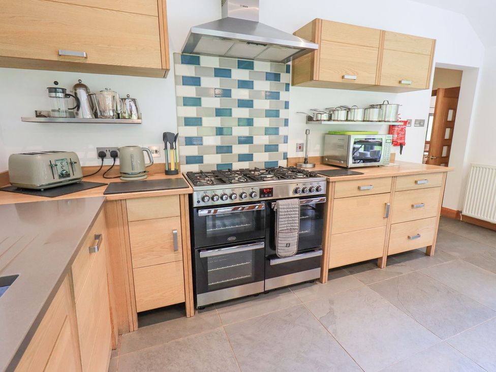 A kitchen with stove and wooden cabinets at Bracken Ground in Coniston
