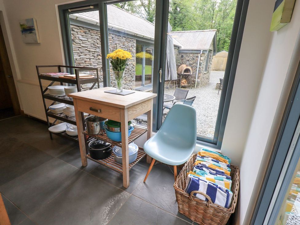 A kitchen with a table, chair, and utensils at Bracken Ground in Coniston