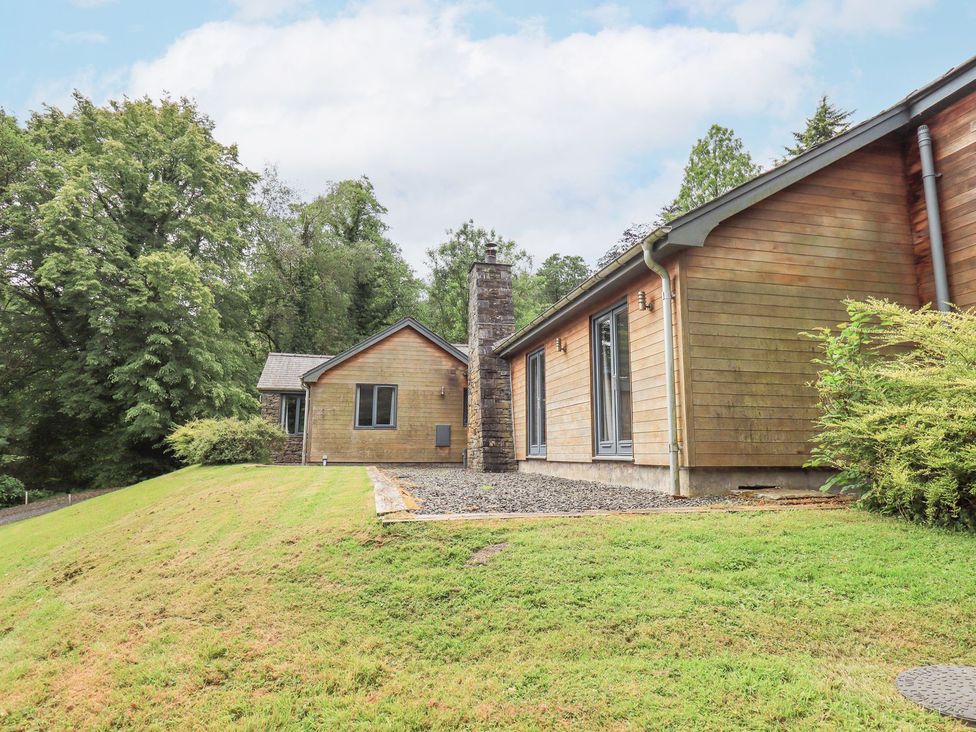 An exterior view of a house with a chimney and landscaping at Bracken Ground in Coniston