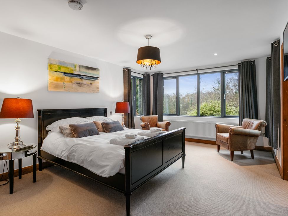A bedroom with a bed and chairs at Bracken Ground in Coniston