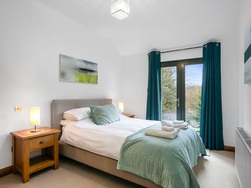 A bedroom with a bed and bedside tables at Bracken Ground in Coniston
