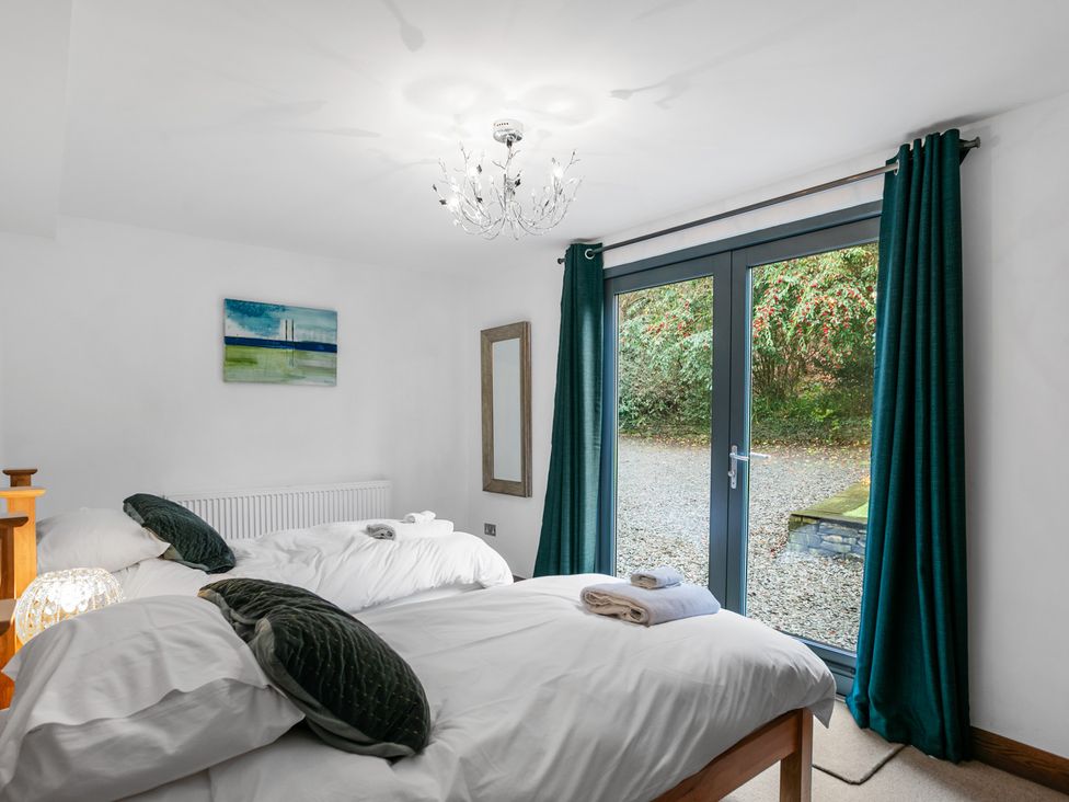A bedroom with two beds and a window at Bracken Ground in Coniston