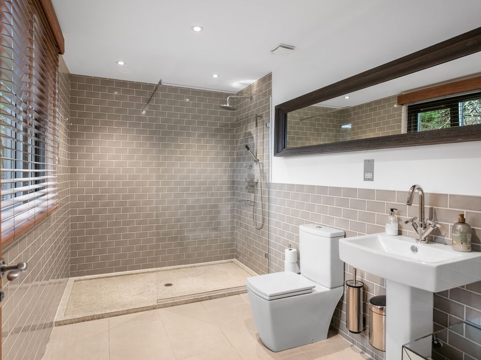 A bathroom with a shower, toilet, and sink at Bracken Ground in Coniston