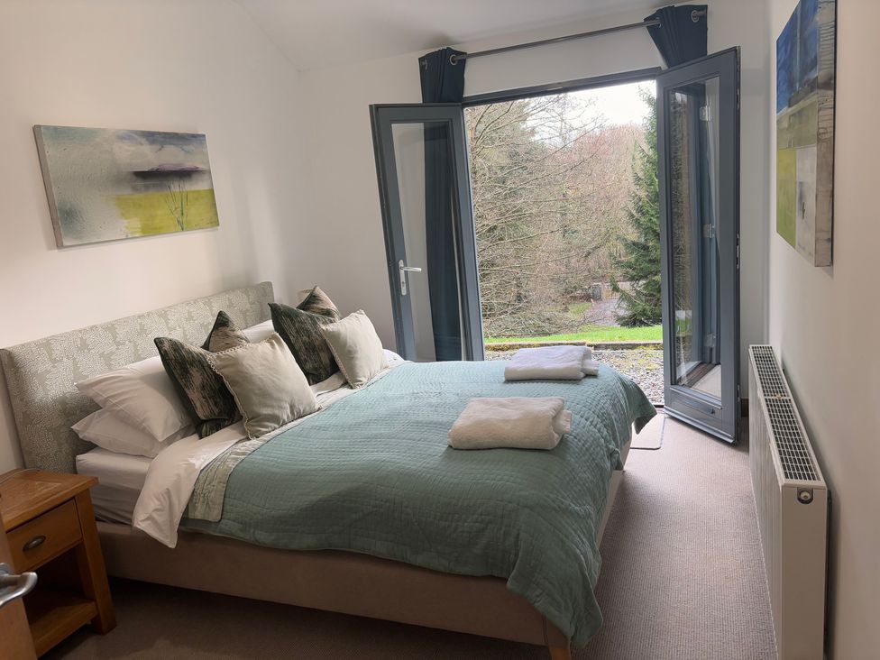 A bedroom with a bed and open windows at Bracken Ground in Coniston
