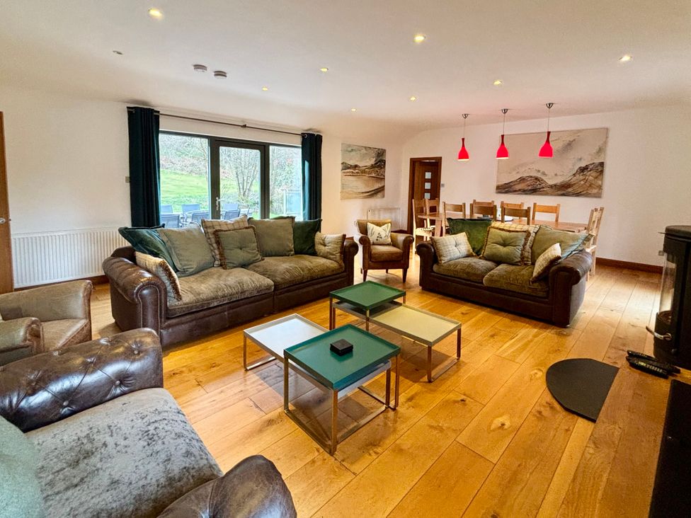 A living room with sofas and a dining table at Bracken Ground in Coniston
