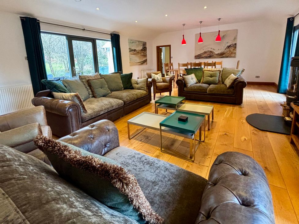 A living room with sofas and a dining table at Bracken Ground in Coniston