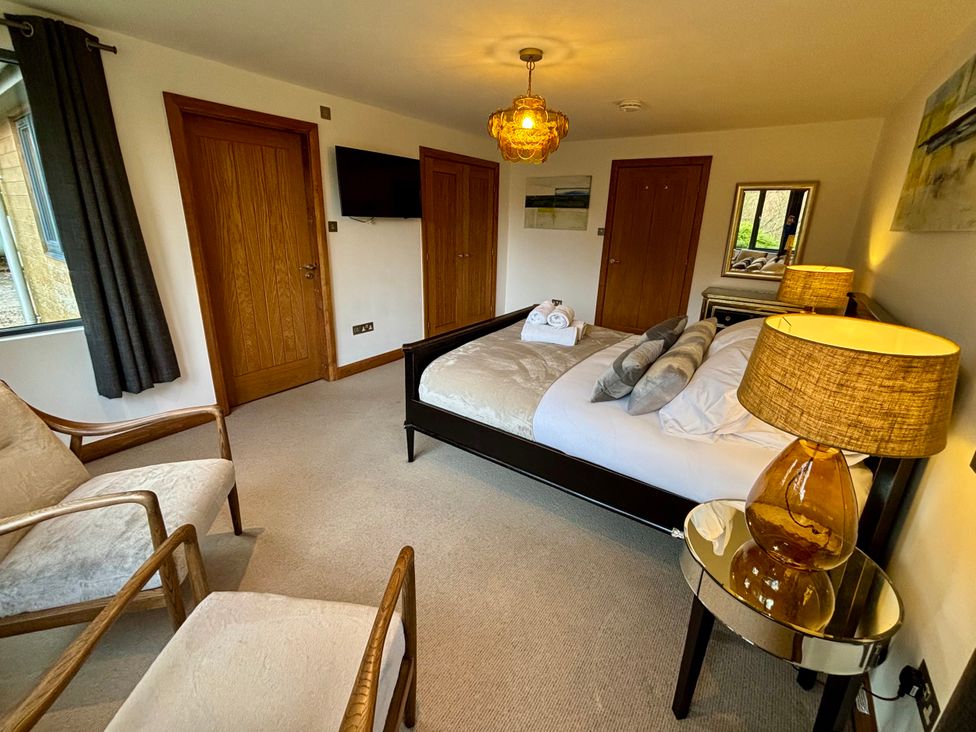 A bedroom with a bed and chairs at Bracken Ground in Coniston