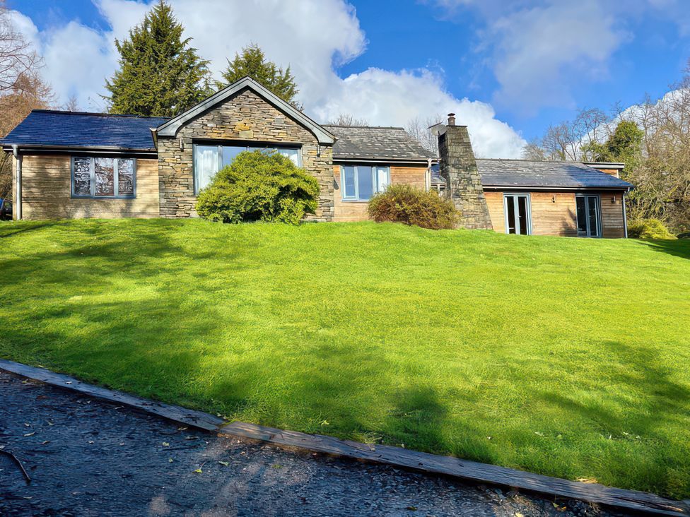 A house surrounded by lawn and trees at Bracken Ground Coniston
