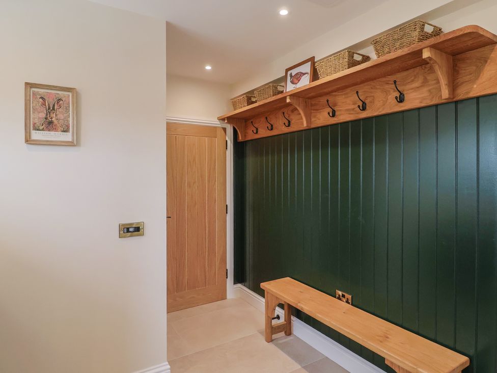 A hallway with hooks and a bench at Foxes Den in Pendomer near Yeovil, Somerset