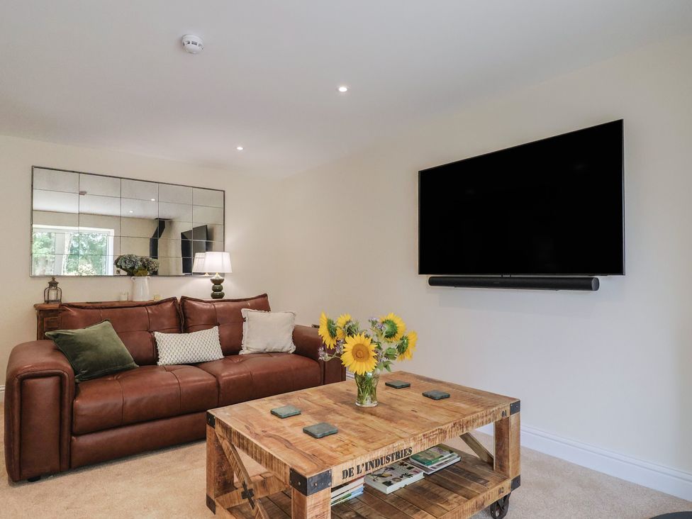 A living room with a sofa and television at Foxes Den Pendomer near Yeovil, Somerset