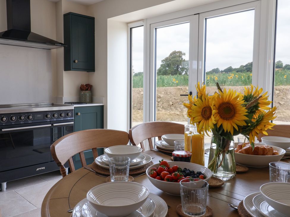 A kitchen with a dining table set for breakfast at Foxes Den in Pendomer near Yeovil, Somerset