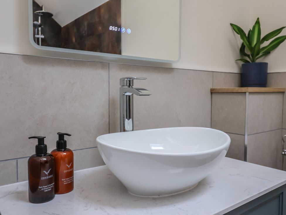 A sink with soap dispensers in a bathroom at Foxes Den in Pendomer near Yeovil, Somerset