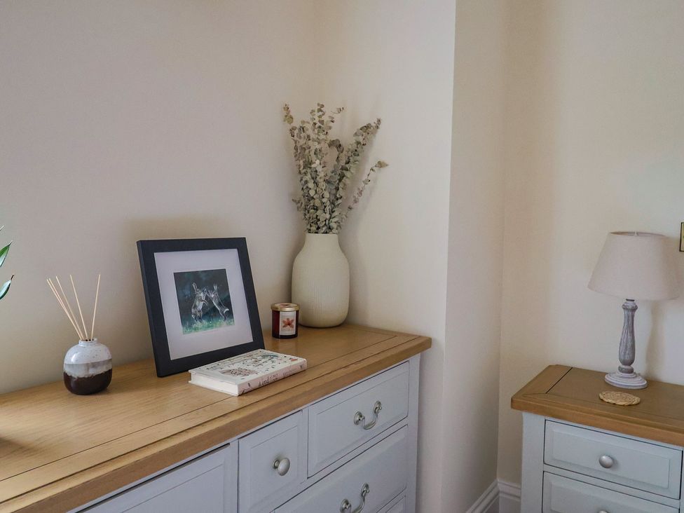 A living room with a dresser, picture frame, and decorative items at Foxes Den, Pendomer near Yeovil, Somerset
