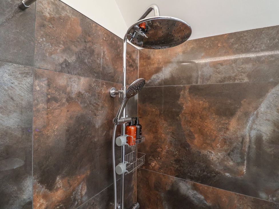 A shower with chrome fittings and shampoo bottles at Foxes Den in Pendomer near Yeovil, Somerset