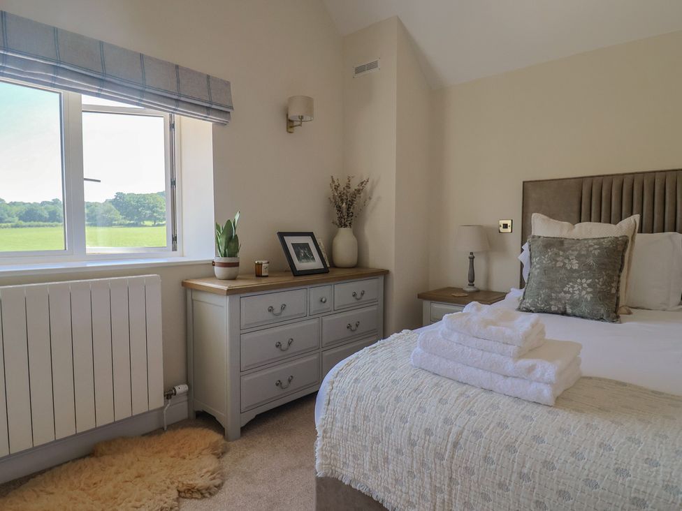 A bedroom with a bed, dresser and window at The Fox Den in East Coker
