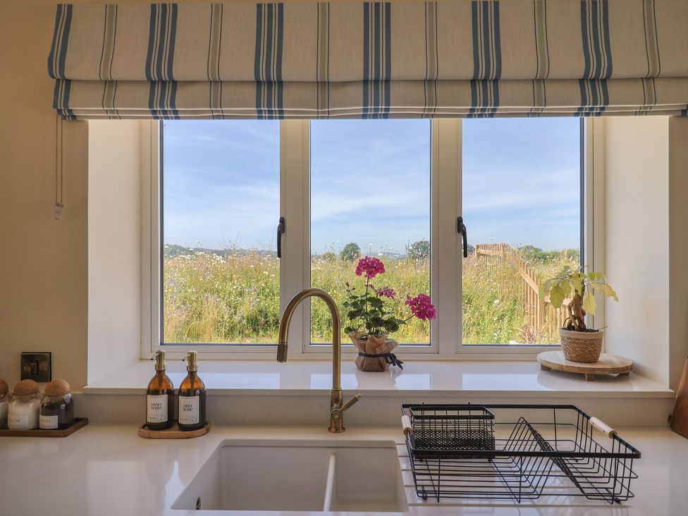 A kitchen with a window and dishes available at The Fox Den in East Coker