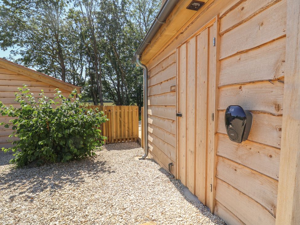 An outdoor area with wooden features and gravel at The Fox Den in East Coker