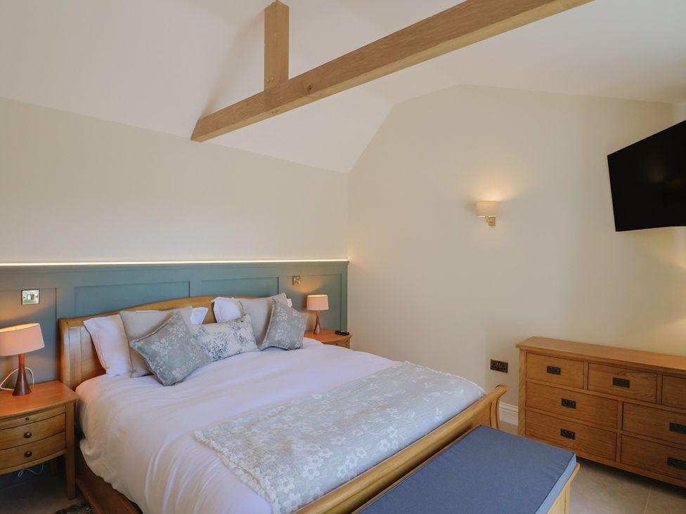 A bedroom with a bed and television at The Fox Den in East Coker
