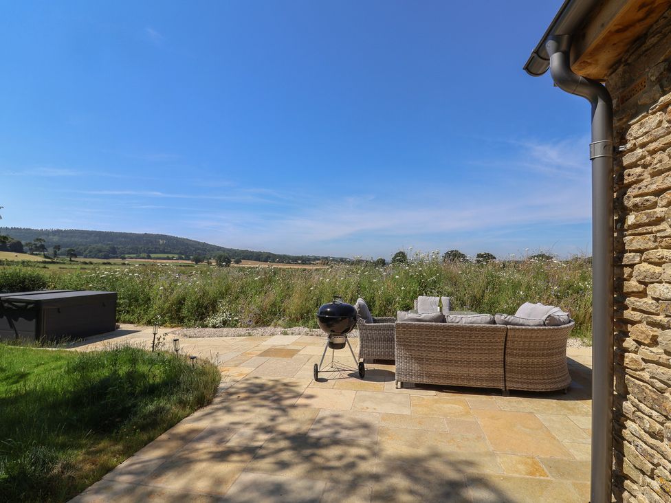 An outdoor area with a sofa and barbecue grill at The Fox Den in East Coker