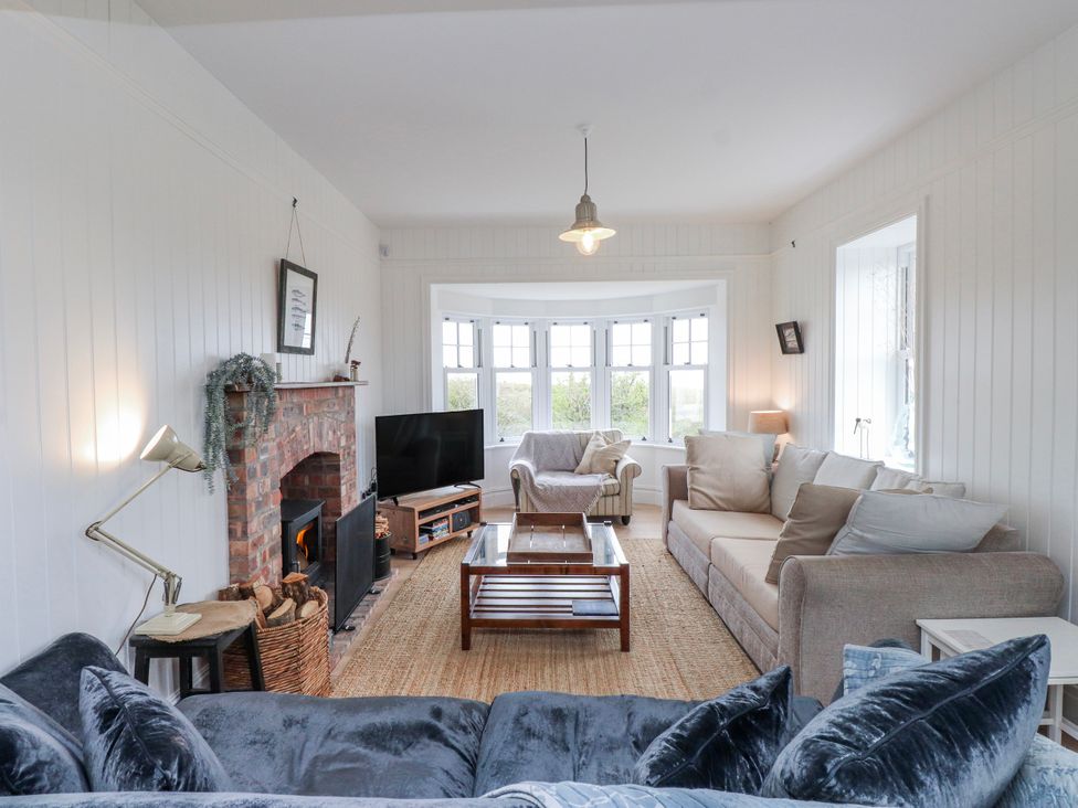 A living room with a fireplace and seating area at 4 bed in Anglesey