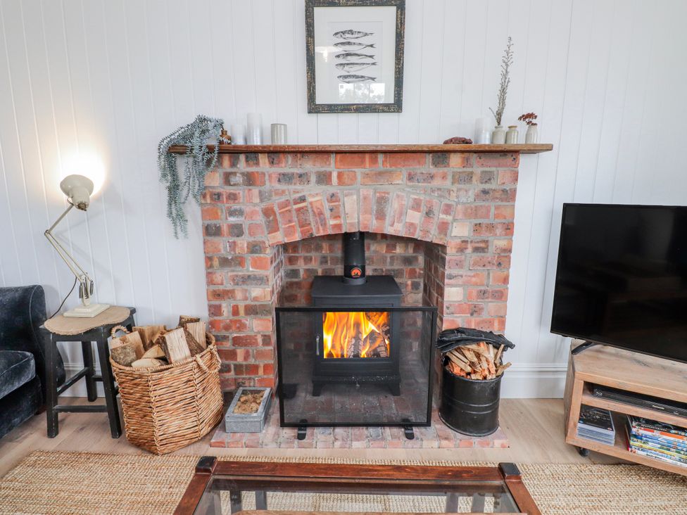A living room with a fireplace and television at 4 bed in Anglesey
