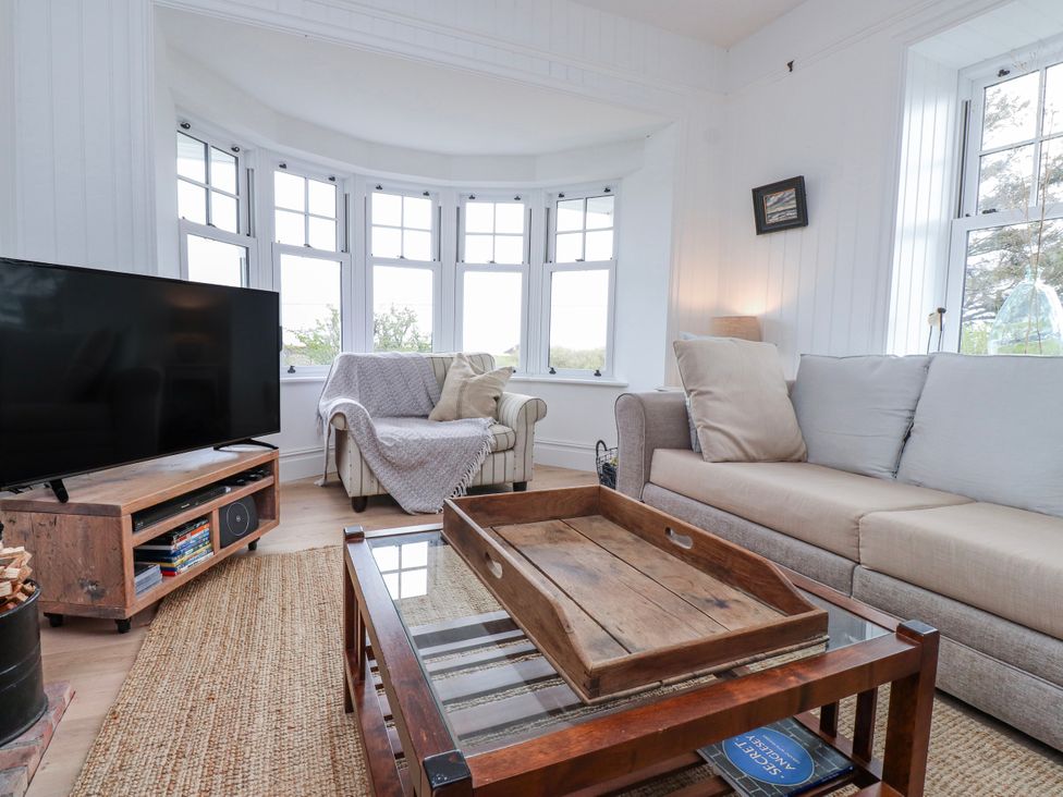 A living room with a television and sofa at 4 bed in Anglesey