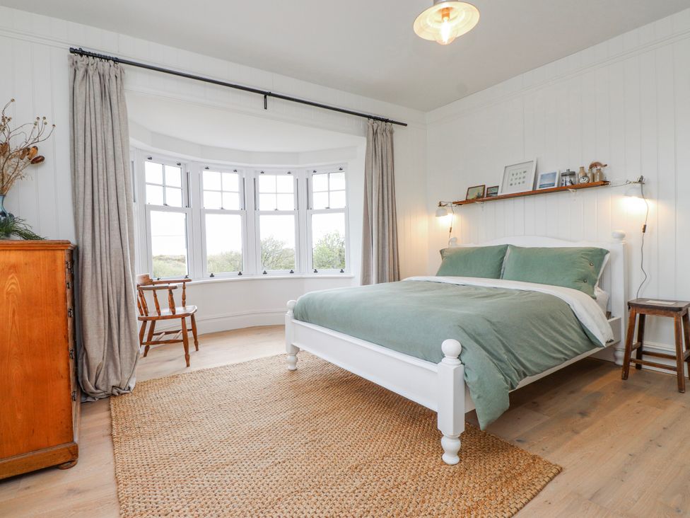 A bedroom with a bed and window at 4 bed in Anglesey