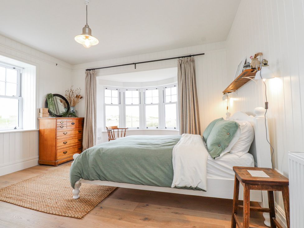 A bedroom with a bed and a window at 4 bed in Anglesey