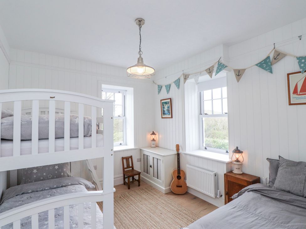 A bedroom with a bunk bed and a guitar at 4 bed in Anglesey