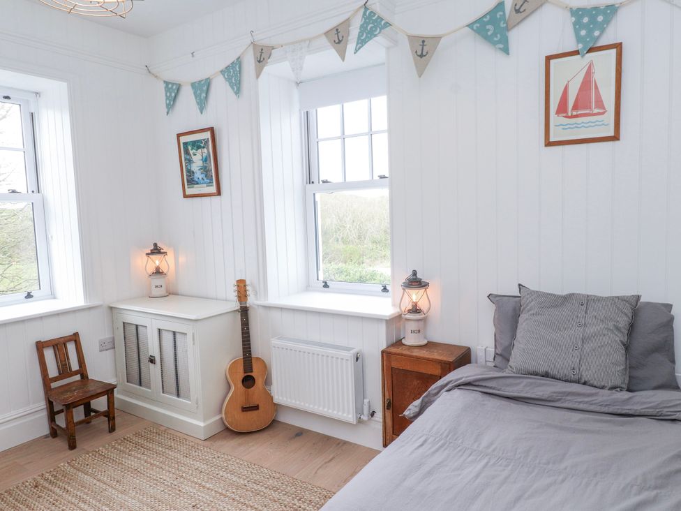 A bedroom with a bed, guitar, and a lamp at 4 bed in Anglesey