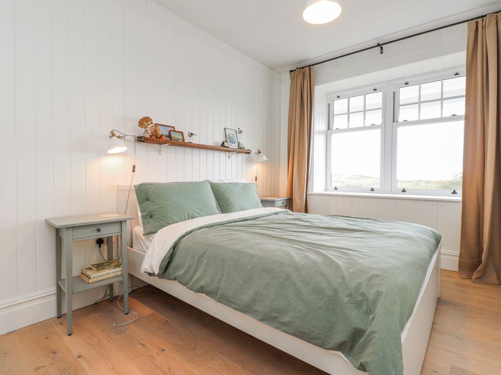 A bedroom with a bed and bedside table at 4 bed in Anglesey
