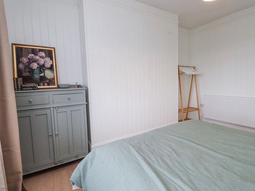 A bedroom with a bed and dresser at 4 bed in Anglesey