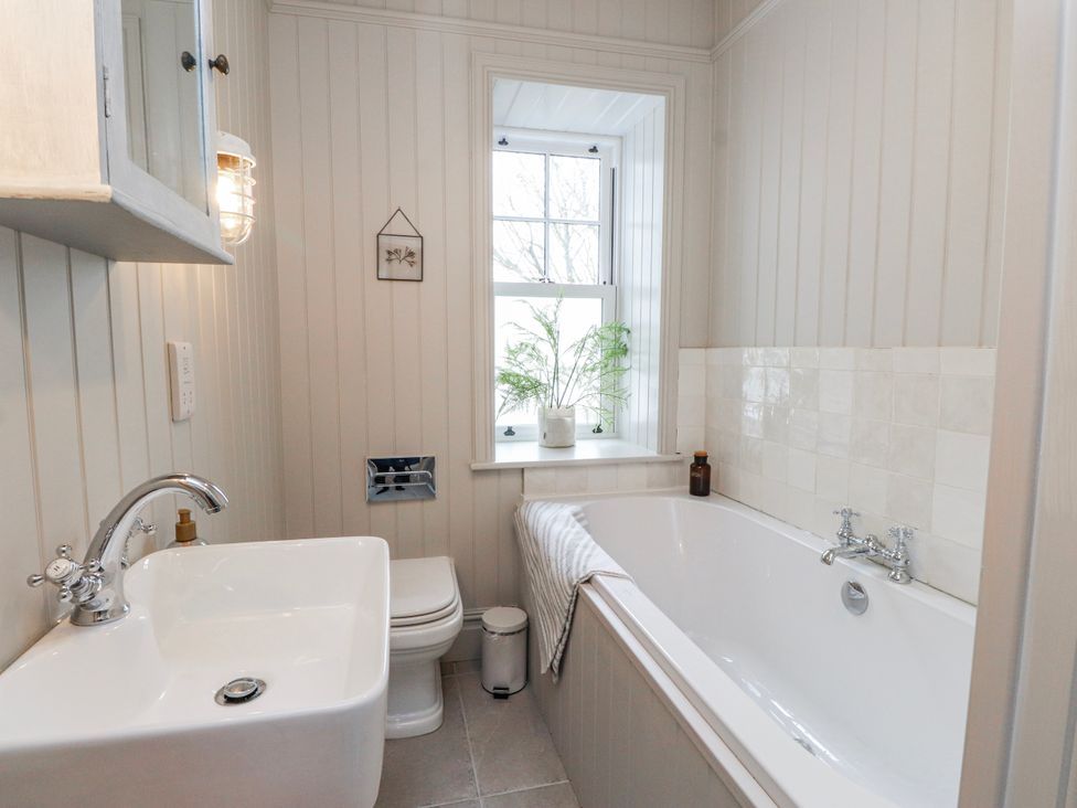 A bathroom with bathtub, sink, and toilet at 4 bed in Anglesey