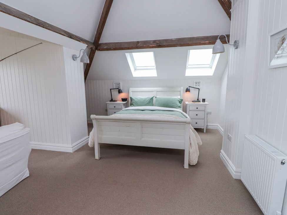 A bedroom with a bed and side tables at 4 bed in Anglesey