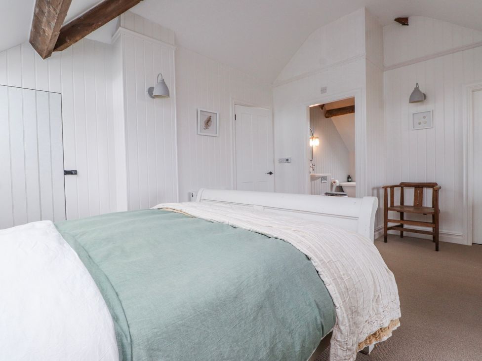 A bedroom with a bed and a chair at 4 bed in Anglesey