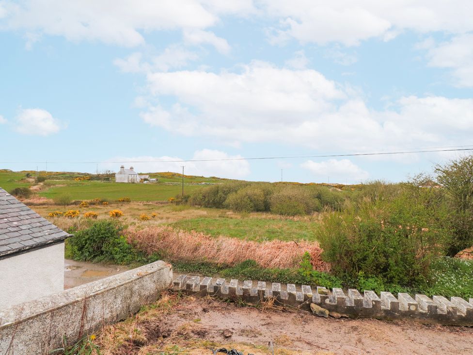 A field with a house and greenery at 4 bed in Anglesey