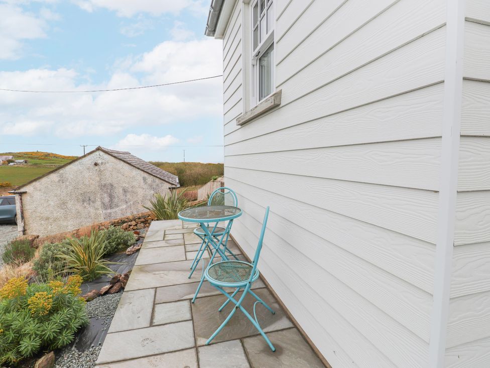 An outdoor seating area with a table and two chairs at 4 bed in Anglesey