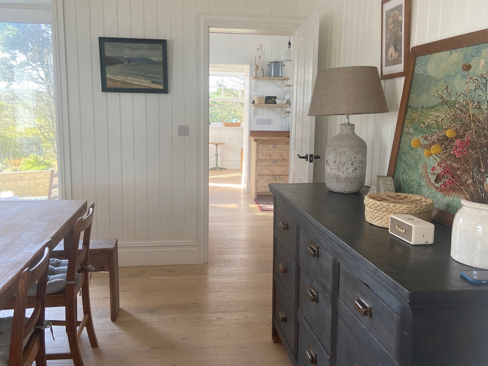 A dining room with a table and chairs at Arfryn in Bull Bay