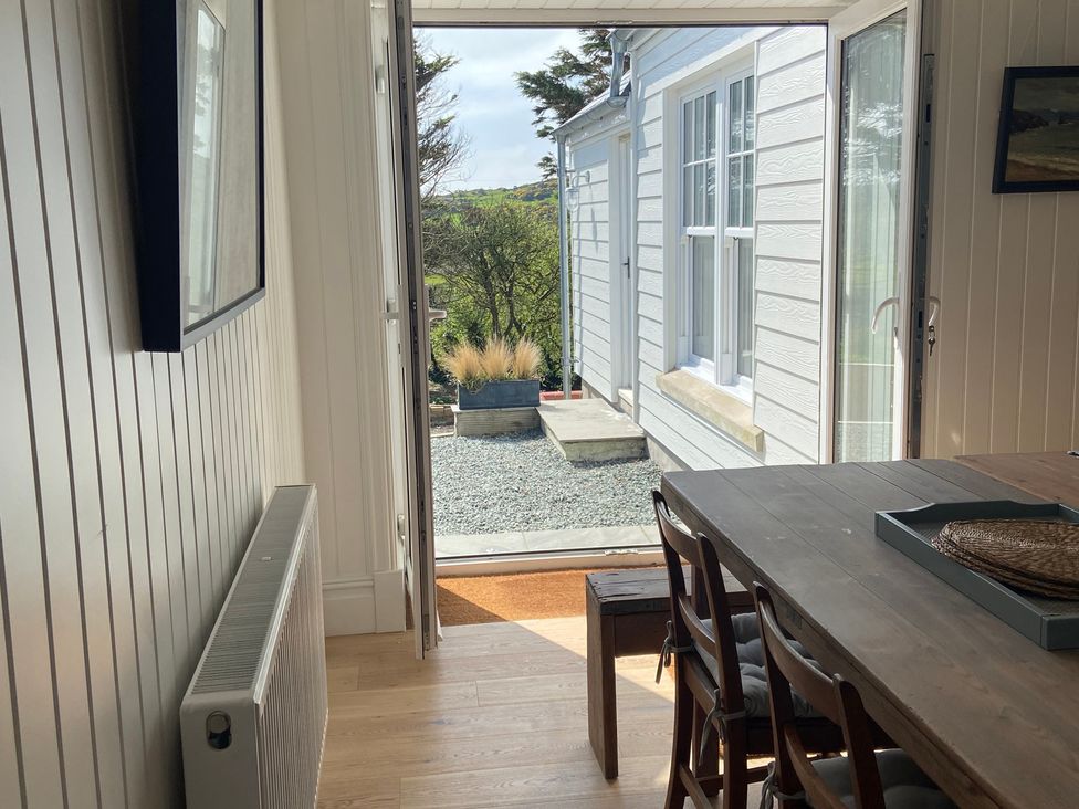 A dining room with table and chairs at Arfryn in Bull Bay