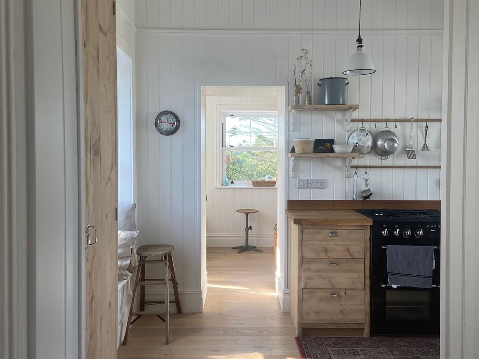 A kitchen with a clock and oven at Arfryn, Bull Bay