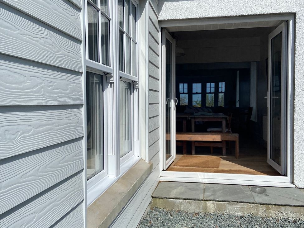 A doorway leading to a dining room with a wooden table at Arfryn Bull Bay