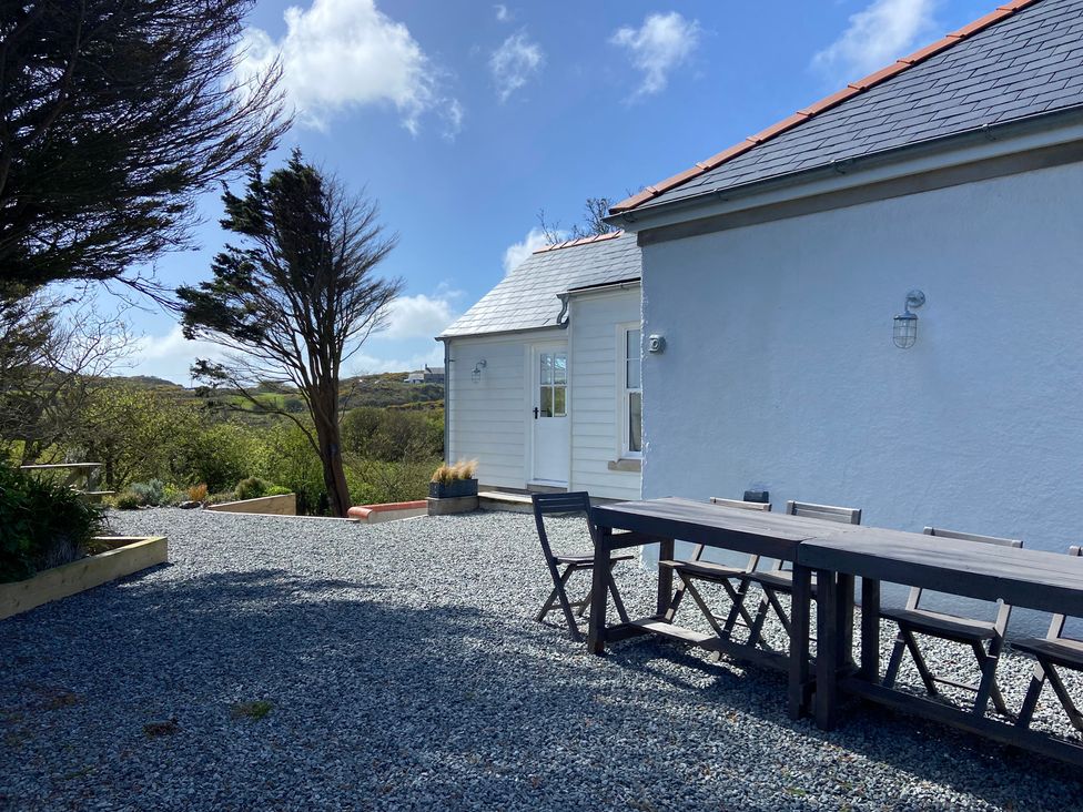 An outdoor area with a large table and chairs at Arfryn in Bull Bay