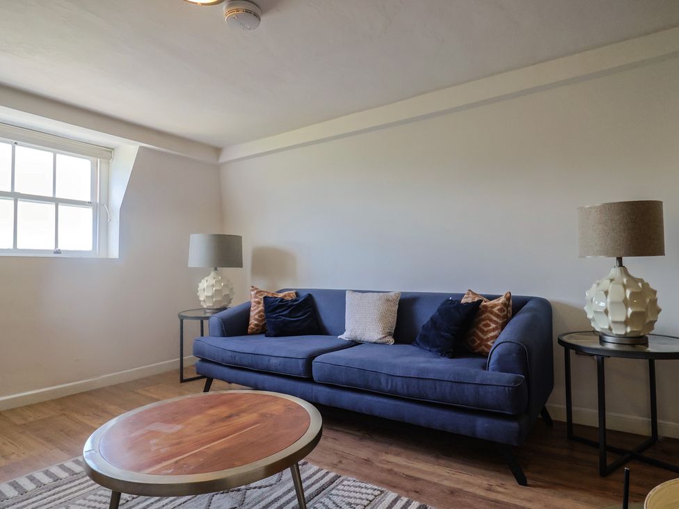A living room with a sofa and round table at FLAT 3 54a broad Street (2 bed sleeping 4) Lyme Regis