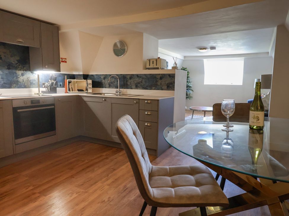 A kitchen with an oven, microwave and dining table at FLAT 3 54a broad Street (2 bed sleeping 4) Lyme Regis