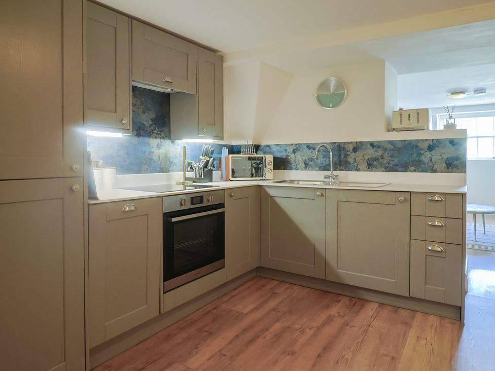 A kitchen with cabinets, oven, microwave, and sink at FLAT 3 54a broad Street (2 bed sleeping 4) Lyme Regis