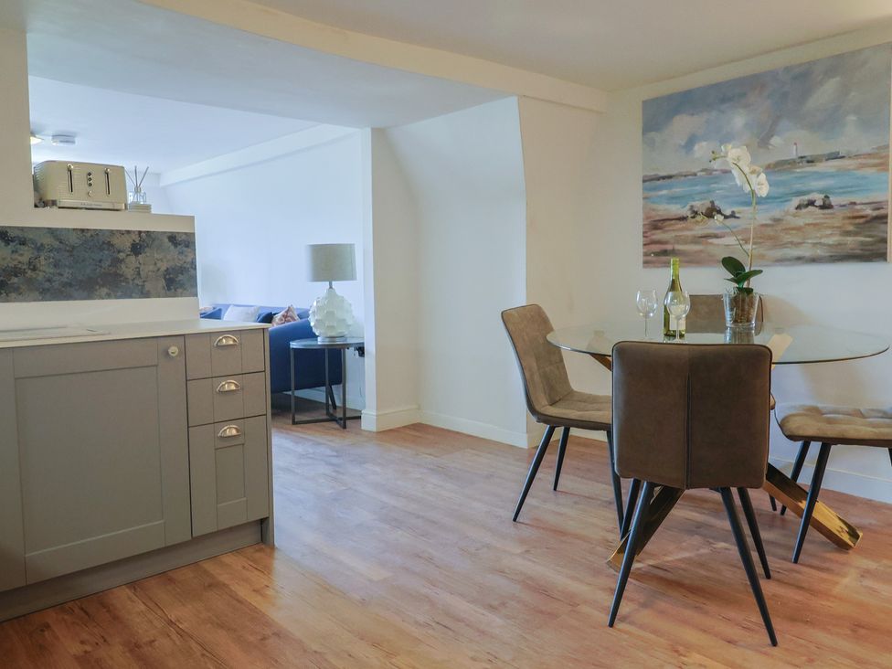 A kitchen with a dining area and a decorative painting at FLAT 3 54a broad Street (2 bed sleeping 4) Lyme Regis