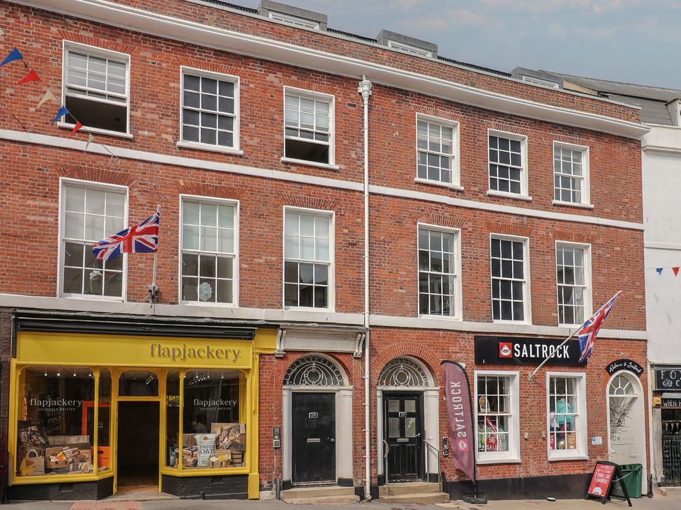 A brick building with storefronts at FLAT 3 54a broad Street (2 bed sleeping 4) Lyme Regis