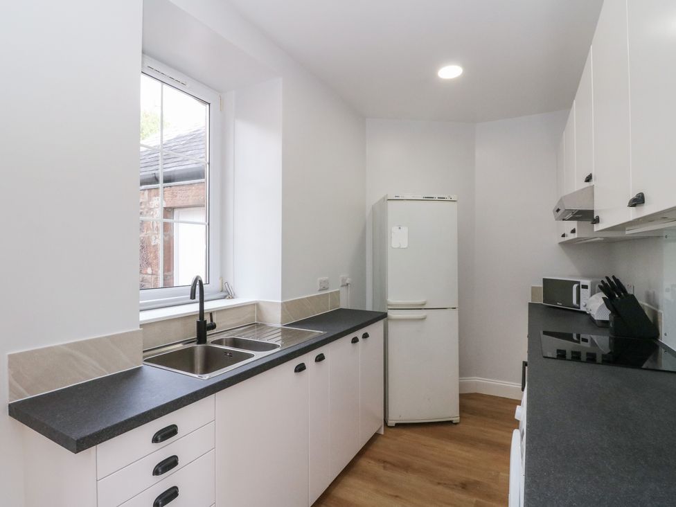 A kitchen with a fridge and sink at 8 Douglas Place