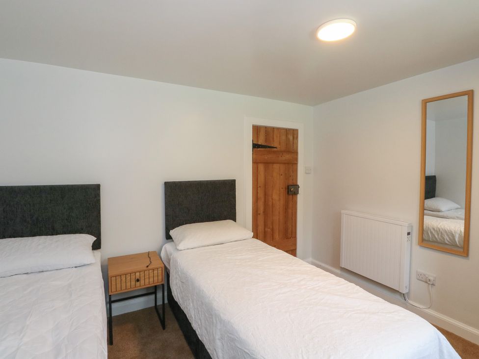 A bedroom with two single beds and a nightstand at 8 Douglas Place