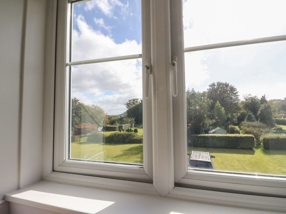 A view from a window showing a garden and trees at 8 Douglas Place